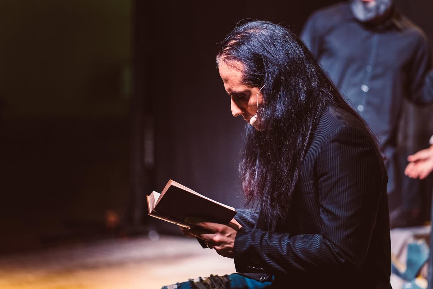 Matteo Siddi legge da un libro sul palco